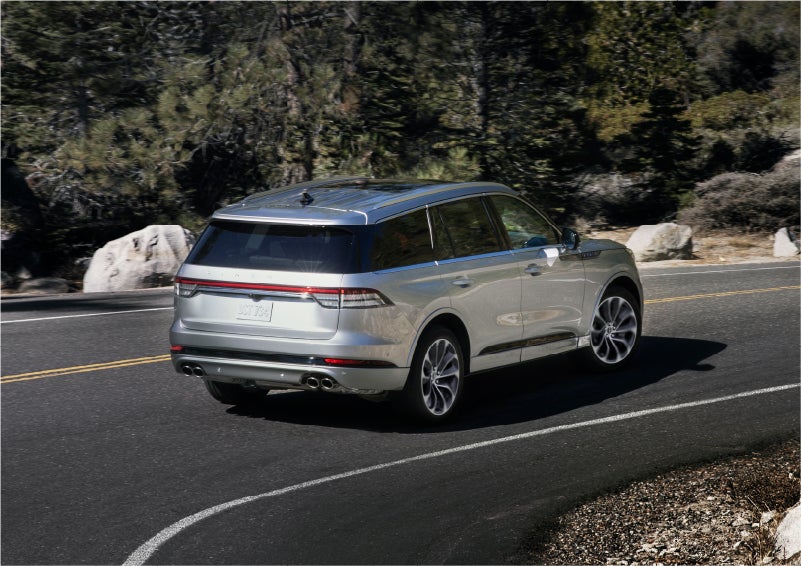 A 2023 Lincoln Aviator® Grand Touring model is shown being driven on a tight turn of a mountain road | Star Lincoln in Southfield MI