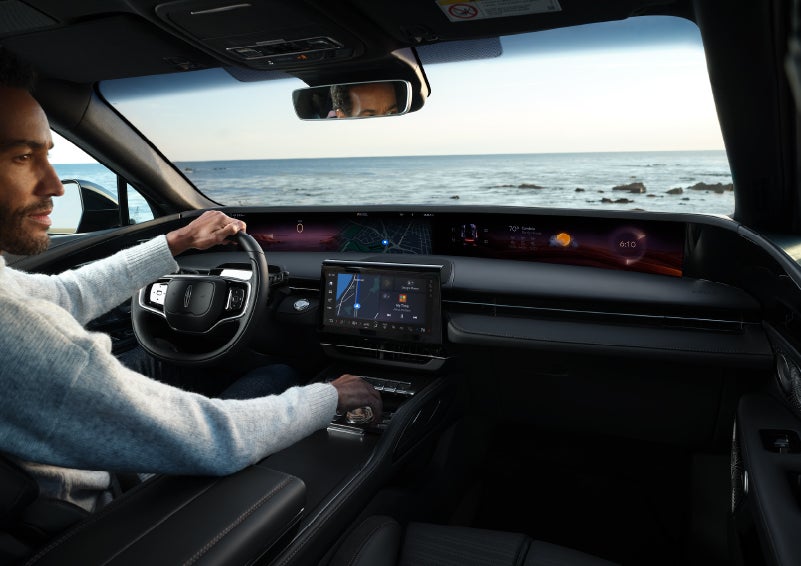 A driver of a parked 2024 Lincoln Nautilus® SUV takes a relaxing moment at a seaside overlook while inside his Nautilus. | Star Lincoln in Southfield MI